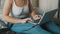 Young woman using laptop in her bedroom. Freelancer working from the comfort of her home