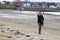 A young woman using a mobile phone on Ballyholme beach in Bangor