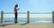 Young woman using mobile phone while standing on the promenade 4k