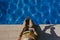 young woman using mobile phone at the swimming pool. Summertime, technology and lifestyle outdoors