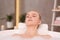 Young woman using pillow while enjoying bubble bath indoors