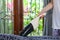 Young woman using a small manual vacuum cleaner while cleaning textile upholstery on the couch