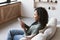 Young woman using smartphone at home. Mixed race girl looking at mobile phone. Communication, social distancing, connection concep