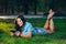 Young woman using tablet outdoor laying on grass