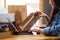 A young woman using tablet pc for online shopping , opening shopping bags and postal parcel box on the table