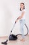 Young woman with vacuum cleaner.