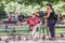 Young woman videographer films older man feeding pigeons in Luxembourg Garden, Paris