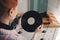 Young woman with vinyl disc near turntable at home