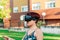 Young woman with virtual reality glasses in a city field. digitization concept