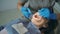 Young woman visiting the dental office. Female lying in dental chair, doctor polishing and cleaning her teeth.