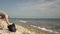 Young woman volunteer ecologist cleans the sea beach from garbage and plastic waste