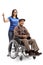 Young woman volunteer pushing a senior man in a wheelchair and showing thumbs up