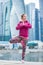 Young woman in Vrksasana pose against the skyscrapers