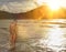 Young Woman Wading in Ocean at Sunset