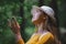 Young woman on a walk outdoors in forest in summer nature, daydreaming.