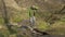 Young woman walking across a stream on the stones