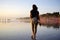 Young woman walking alone on beach at sunset with bare foot. Seminyak Beach, Bali, Indonesia