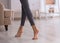 Young woman walking barefoot at home, closeup