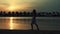 Young woman walking at beach. Barefoot girl spending sunrise time at seaside.