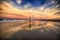 Young woman walking on the beach near the ocean and walking away at the sunset