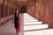 Young woman walking in colonnade walkway