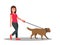 Young woman walking dog on leash. Girl leading pet in park