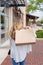 Young woman walking down the sidewalk holding shopping bags