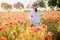 Young woman walking and enjoying among flowering poppies