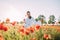 Young woman walking and enjoying among flowering poppies