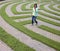 Young Woman Walking Through Maze with Cellphone