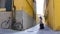 A young woman walking through the narrow yellow streets with luggage