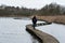 Young woman walking over wooden path from a birdhouse in the lake in the Flemish nature reserve Het Vinne, Zoutleeuw