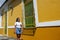 Young Woman walking past colonial house in Barranquilla, Colombia