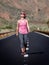 Young woman walking on the road in Teide volcano crater