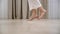 Young woman walking tiptoe barefoot on a warm wooden floor at home, Slow motion