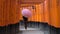 Young woman walking through Torii Gates with umbrella