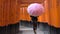 Young woman walking through Torii Gates with umbrella