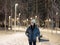 Young woman walking on walkway among snowy winter park at night