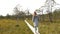 Young woman walking on wooden boardwalk through bog swamp land