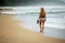 A young woman walks alone on the beach