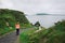 Young woman walks along pathway surrounded by irish landscape