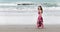 Young woman walks barefoot along the ocean shore