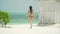 Young Woman Walks Barefoot On Beach