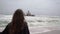 Young woman walks at the beach near sunken trawler, shipwreck. Old ship Zeila.