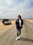 Young woman walks on highway in desert. Girl on center of the road, barefoot.