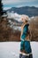 Young woman walks on snow against beautiful landscape of mountains