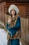 Young woman walks on snowbound street along wooden fence