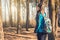 Young woman walks in a spring pinewood.