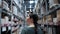 A young woman walks through the warehouse and looks for goods on the shelves. Rear view. Real time.