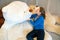 A young woman wants to kiss a big plush polar bear